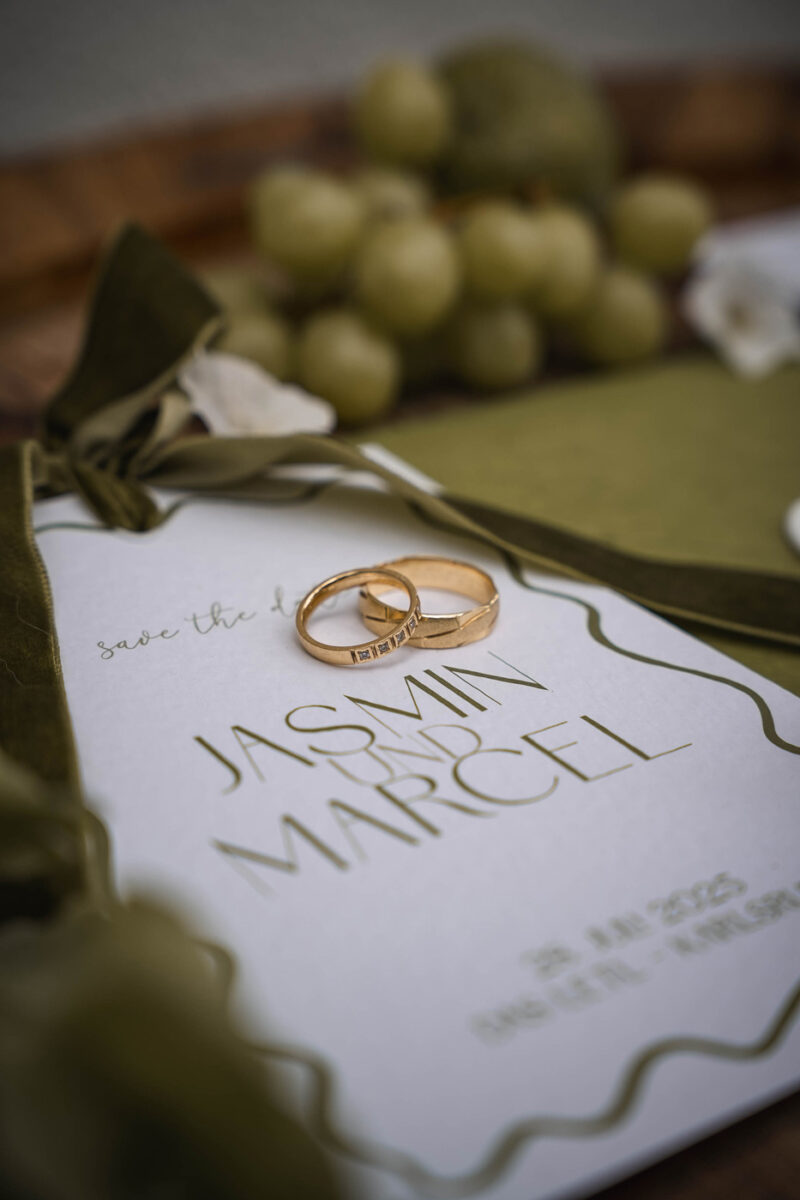 Hochzeitseinladung und Hochzeitsringe - Details während einer Hochzeit