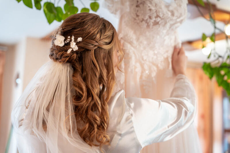 Braut schaut sich ihr Hochzeitskleid an