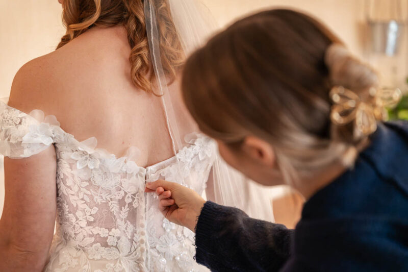 Das Hochzeitskleid wird zugemacht